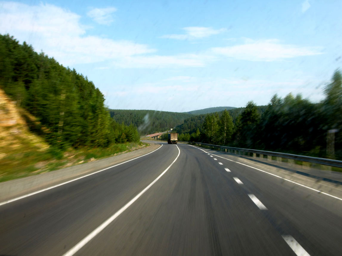 the blurry po shows a freeway with two lanes and trees