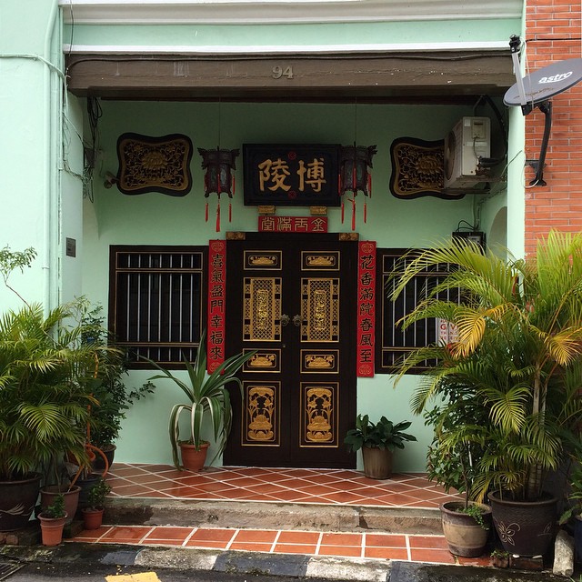 the front door of an oriental style building with two double doors and three windows