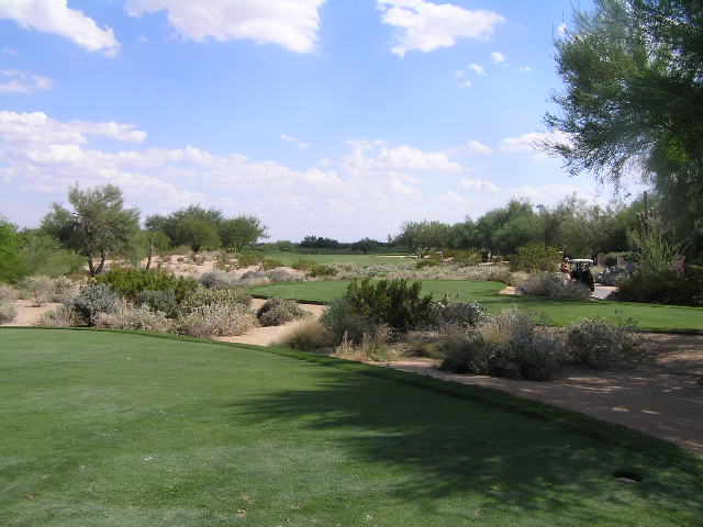 a dirt path leading to an empty golf course