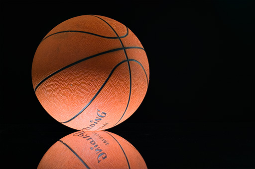 the basketball sits on top of another orange basketball