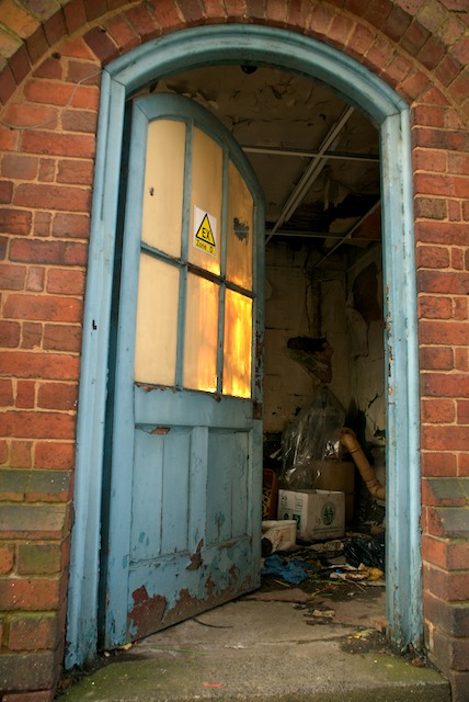 the old building is filled with junk and open doors