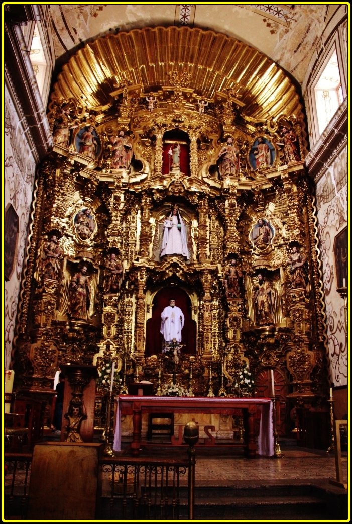 a church with a gold alter with statues of people and artwork