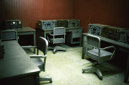 a room filled with computer equipment next to a white chair