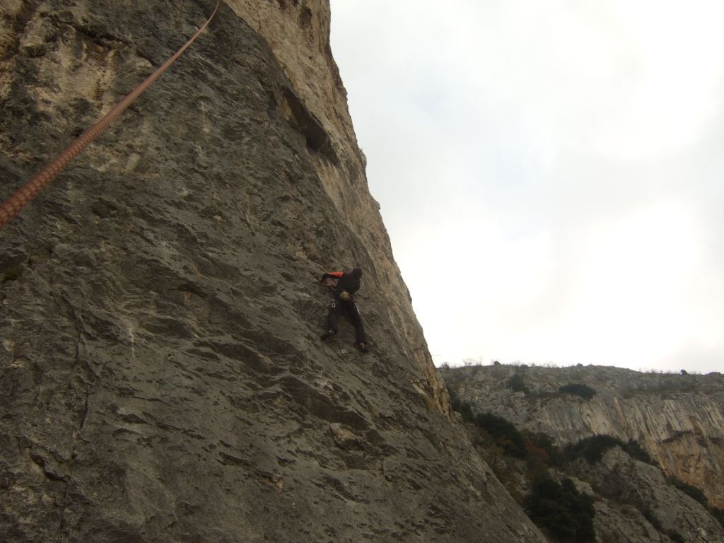 a man climbing a cliff on a rope