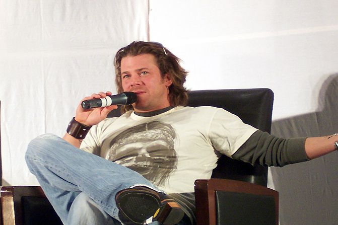a man is sitting in a chair with a microphone
