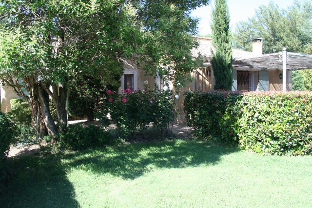 large trees are surrounding the house and bushes