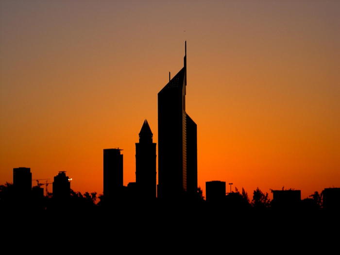 silhouette of a city with large buildings at sunset