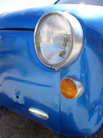 a closeup of a blue car with the headlights turned