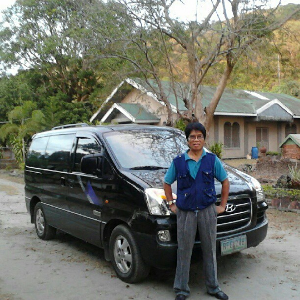 a man standing beside an suv on the side of a road
