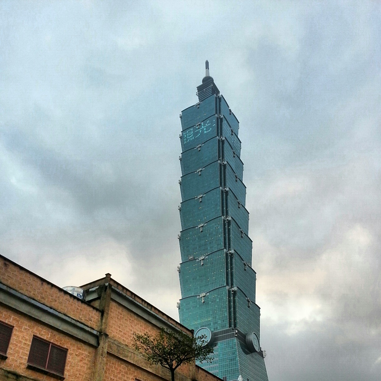 a tall skyscr with a massive blue window