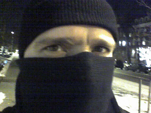 man in black scarf and knit hat at night