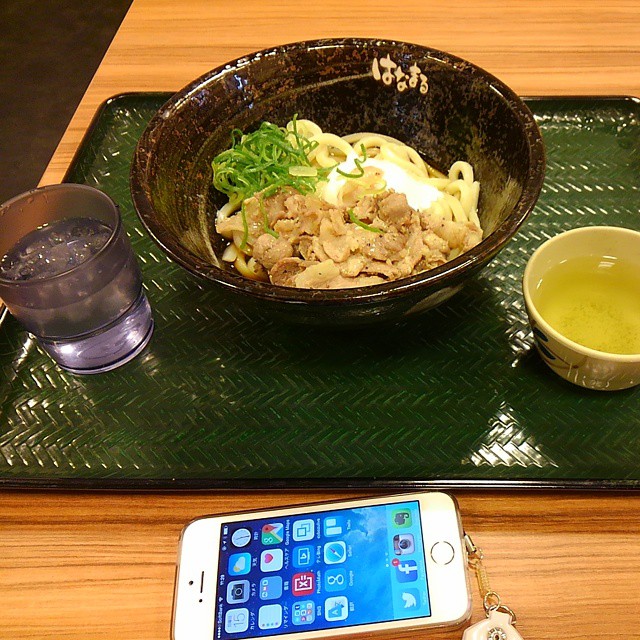 a black bowl with food in it sitting next to an iphone