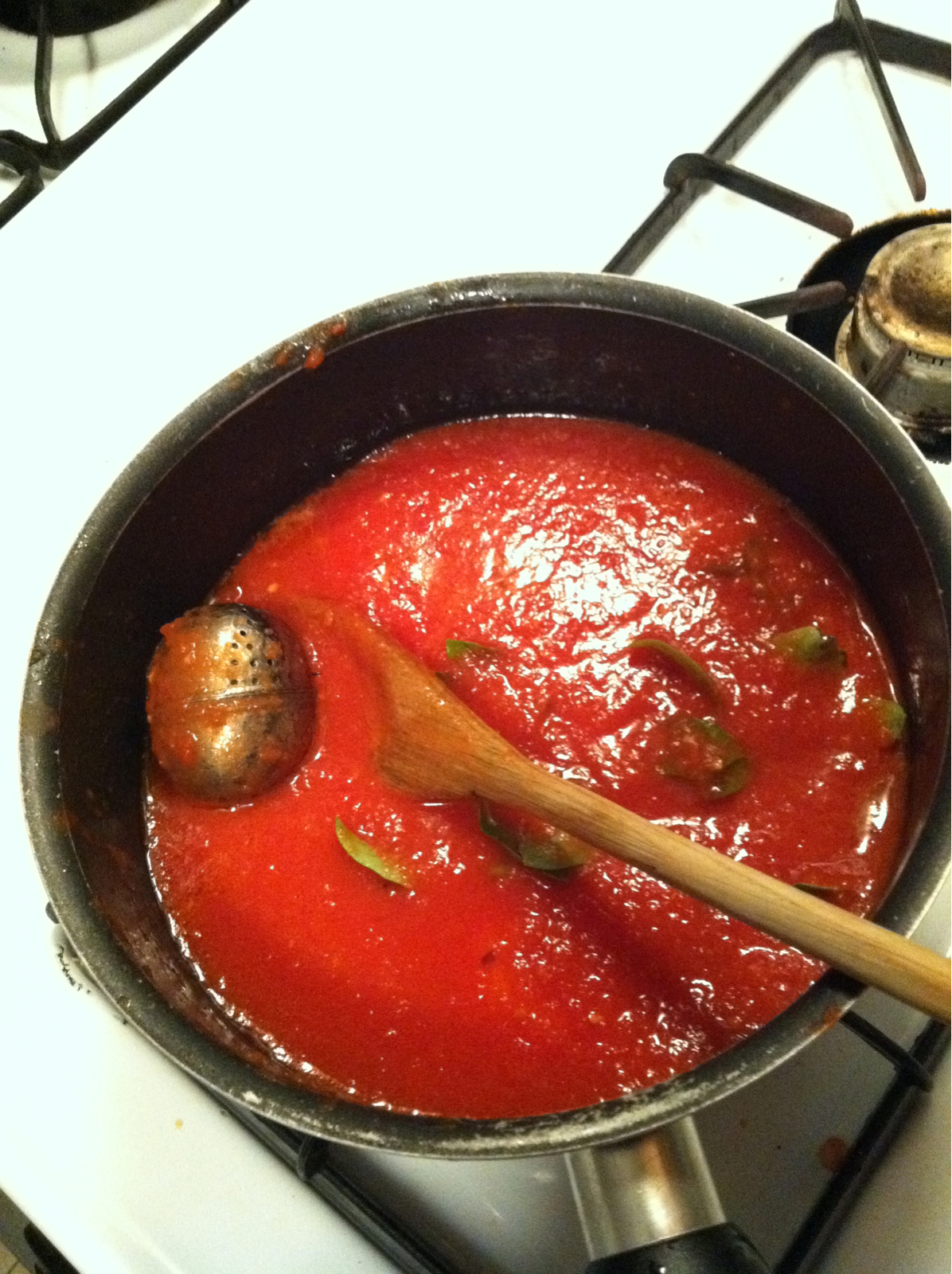 tomato sauce being prepared in a pot on the stove