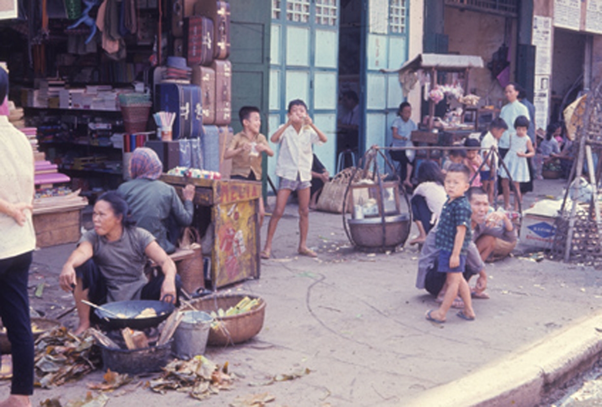 people and vendors are near an alley with many open windows