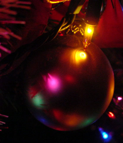 a christmas tree with a shiny red ornament