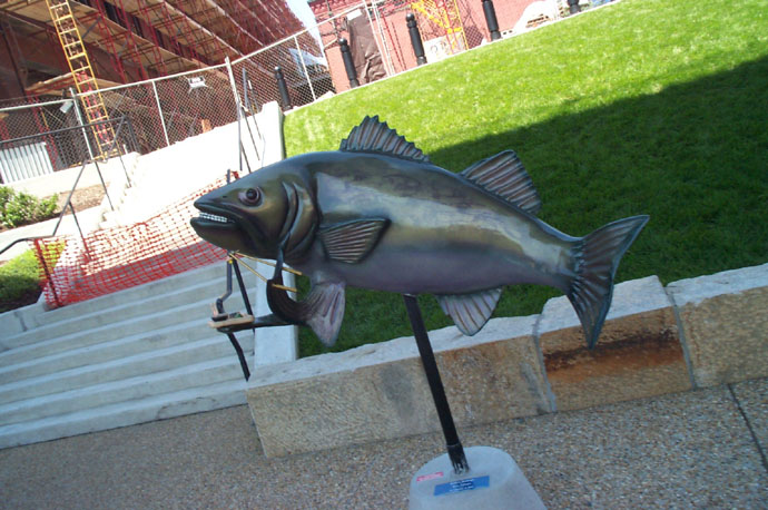 a sculpture of a fish is shown on a small pole