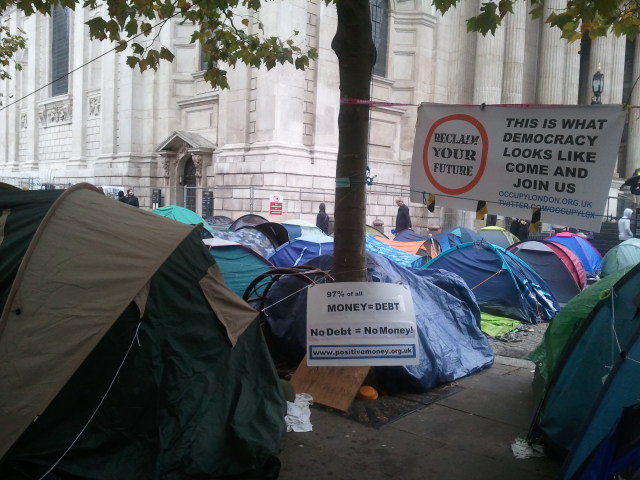 many tents are outside with signs in the background