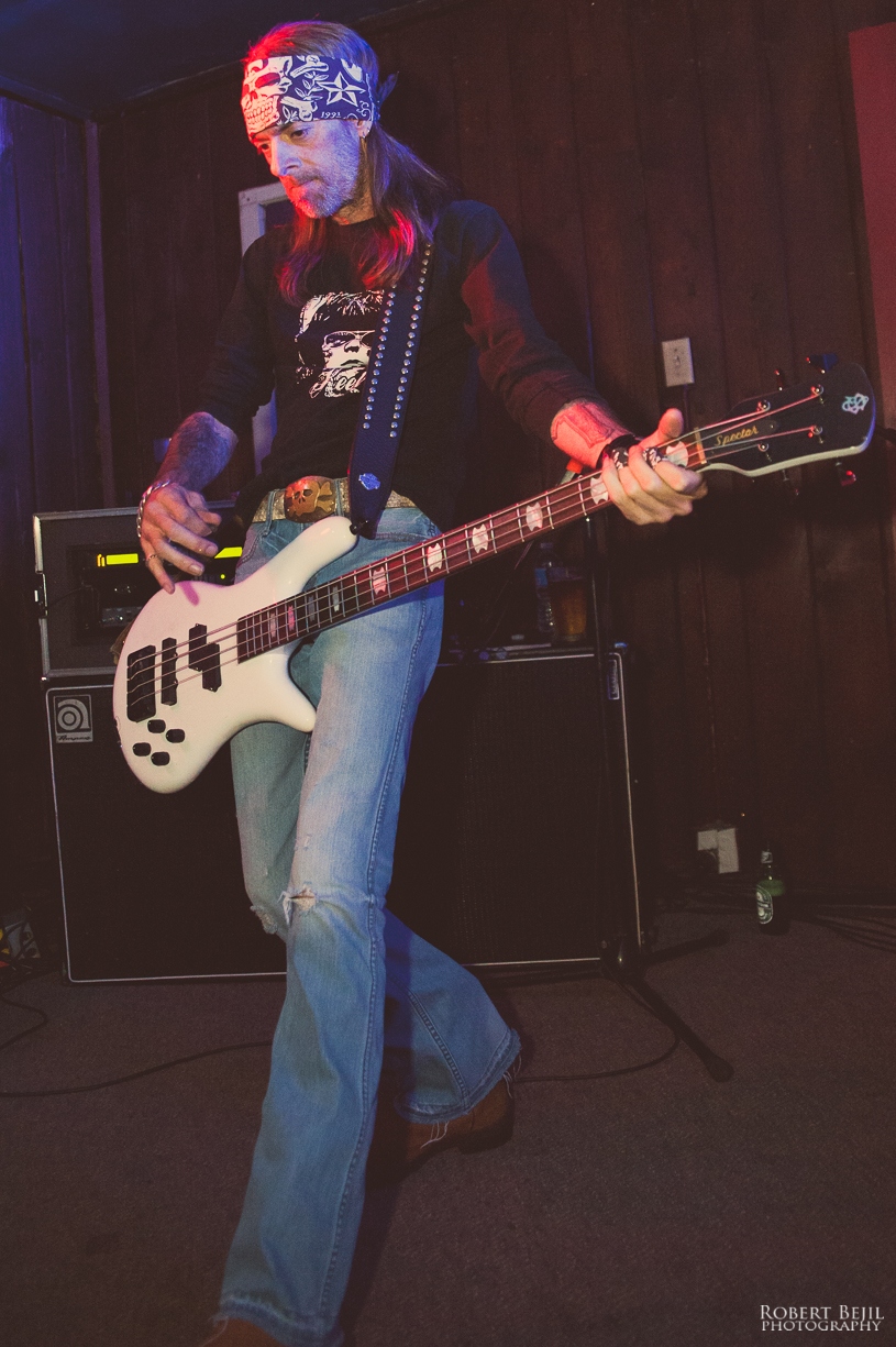 a man holding onto his guitar while singing