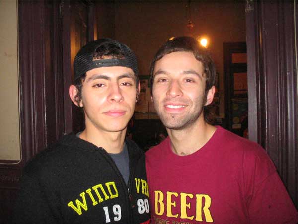 two guys are standing next to each other in a room