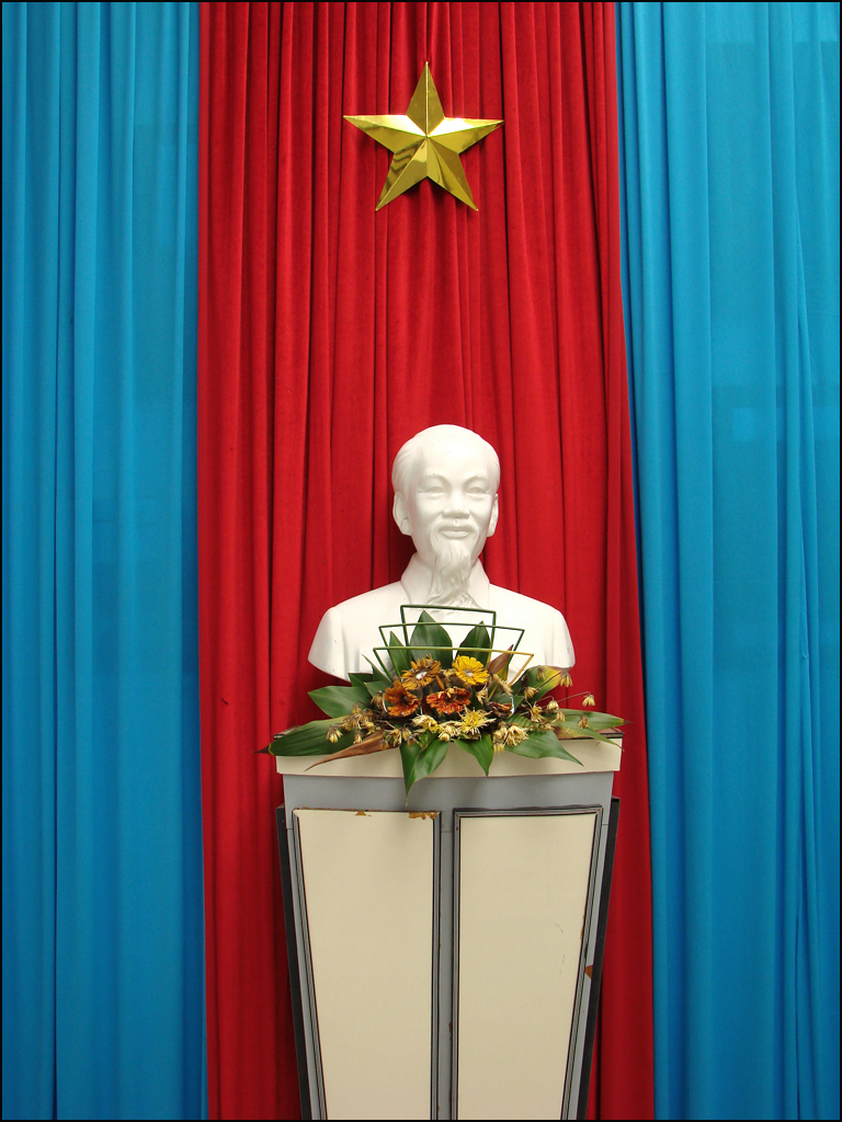 a white statue with flowers sitting on top of a podium