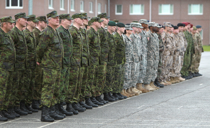 a row of military men standing in front of a building