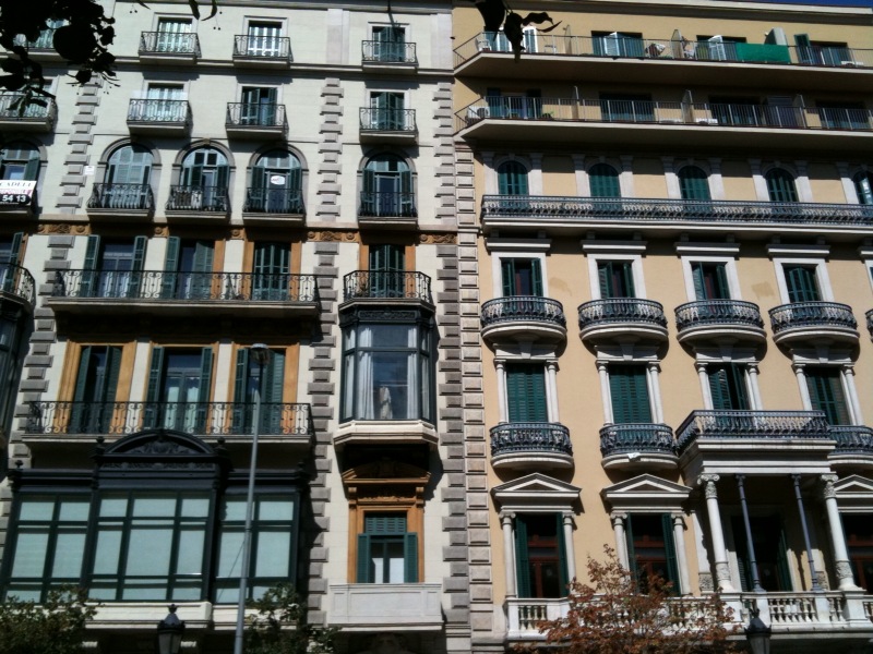 a large beige building with balconies and windows