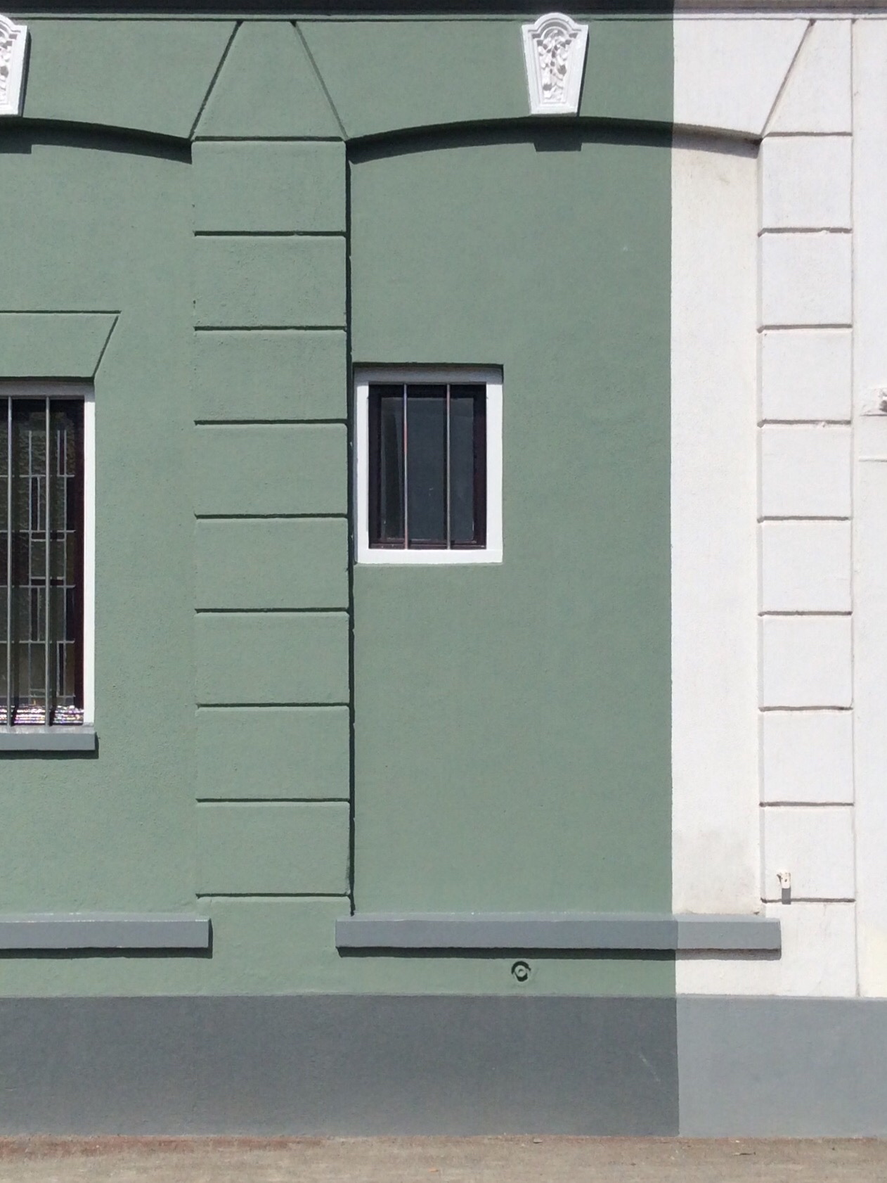 a building with green shutters and windows is empty