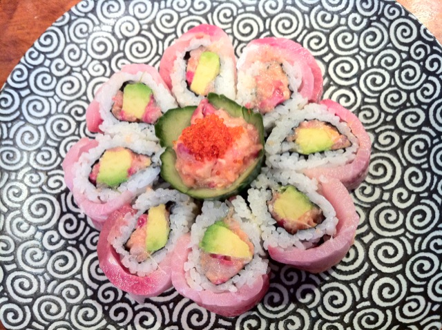 sushi rolls and other sushi with a colorful red sauce