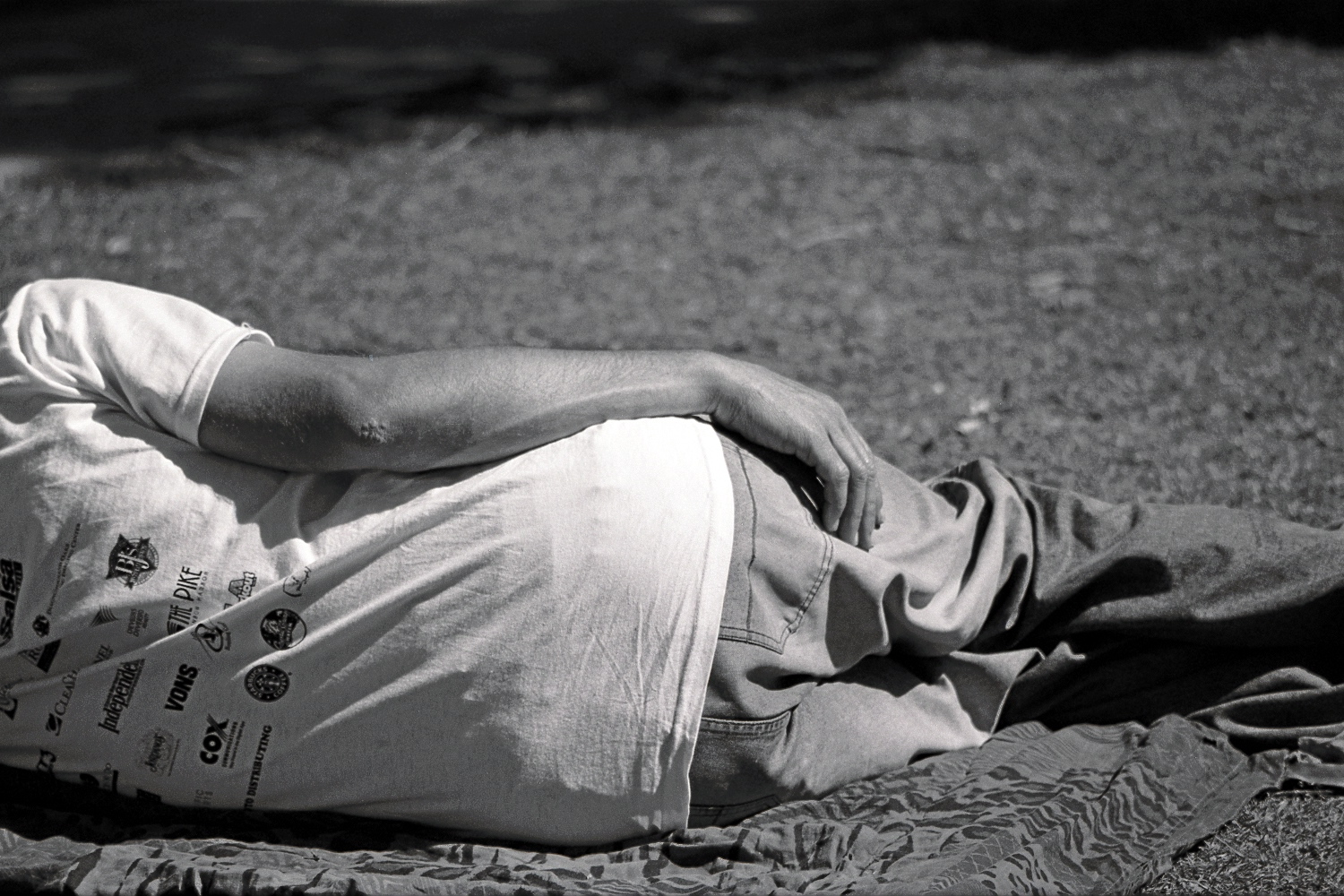 a man laying on top of a towel covered in grass