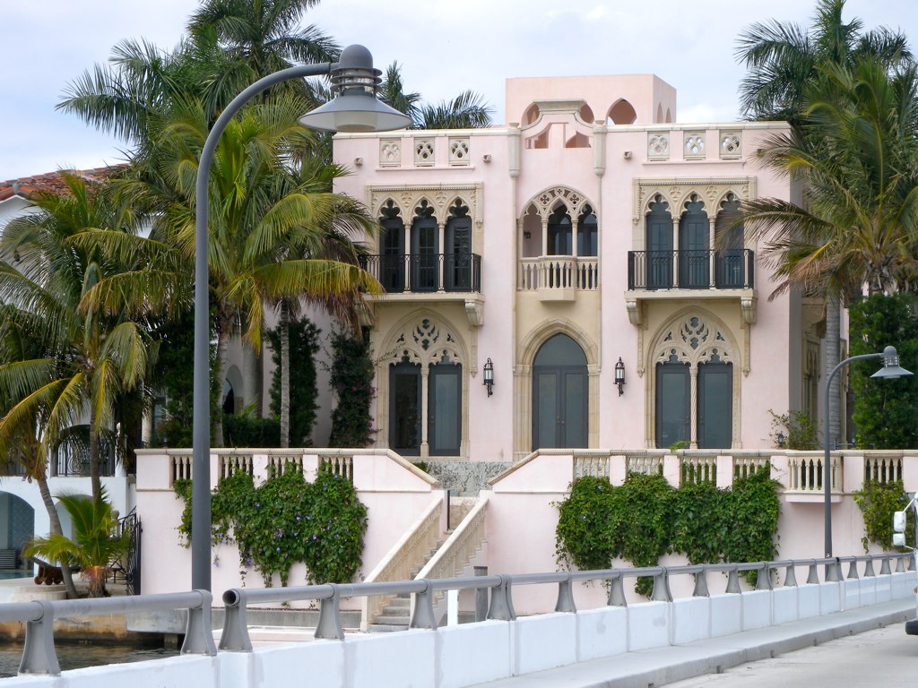 a pink building is surrounded by palm trees