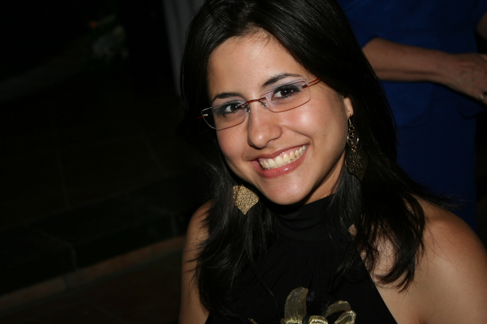 a woman wearing glasses, smiling for a po