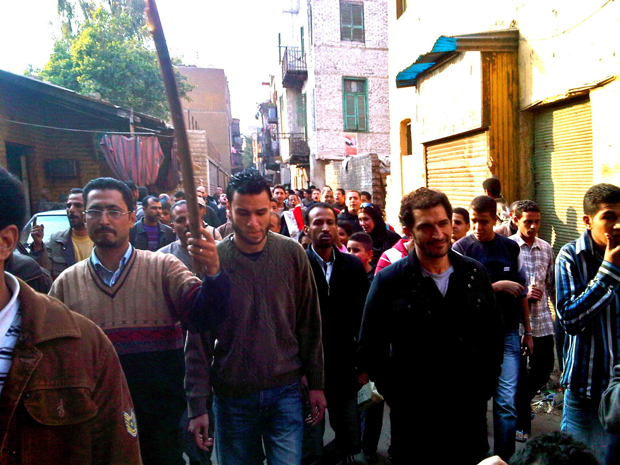 a group of men walk down the street in a small town