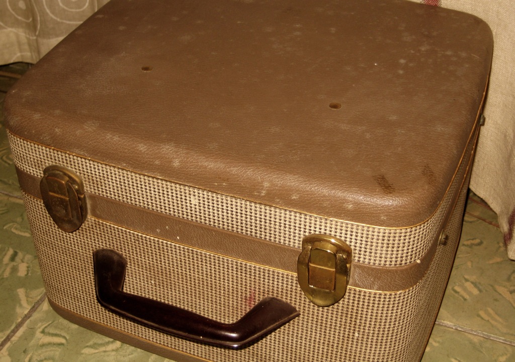 the brown suit case is made out of rattan