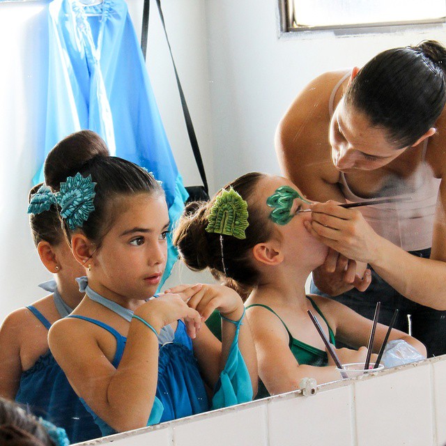 a person standing in front of a mirror trying on some hair