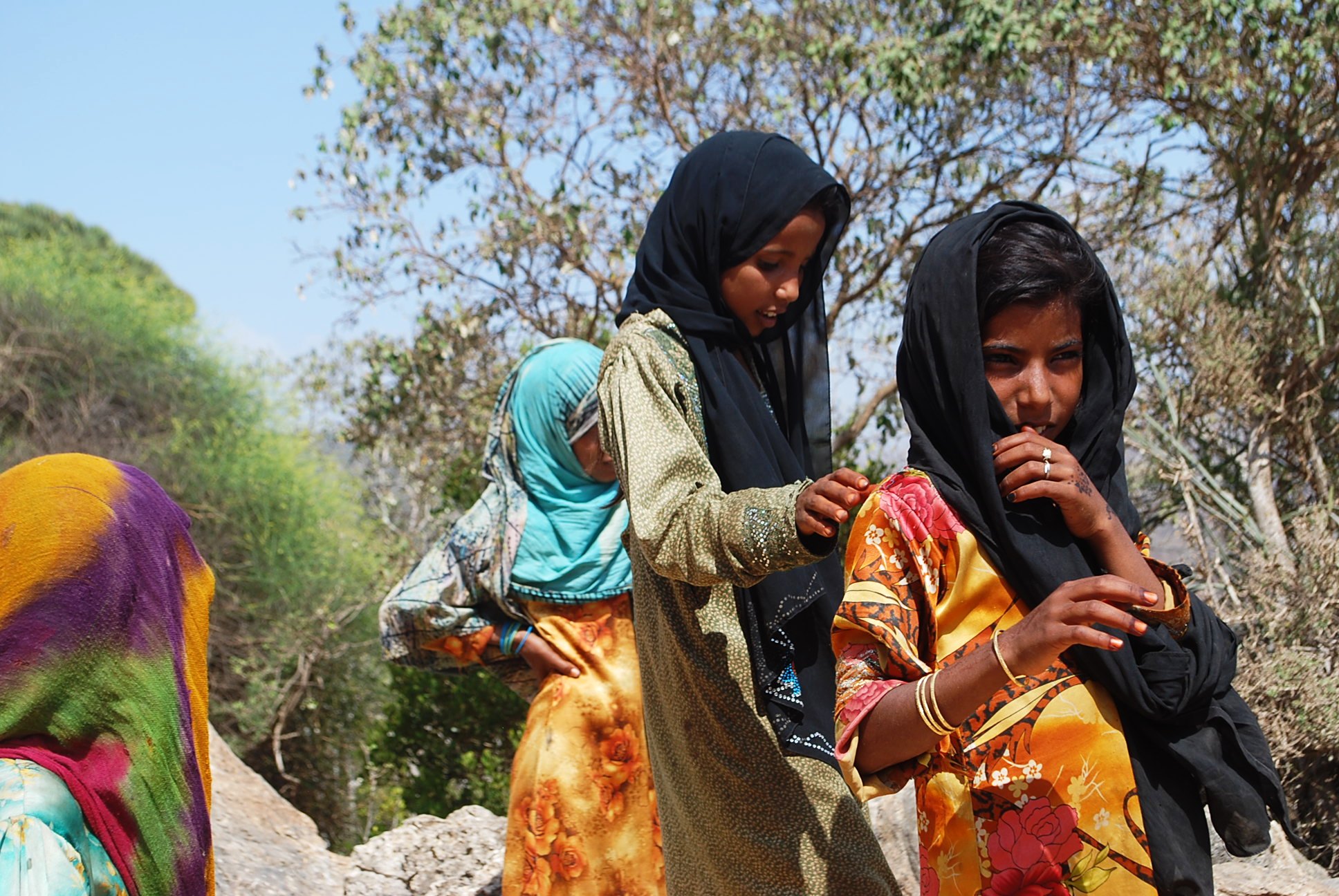 three women are walking outside wearing headscarves