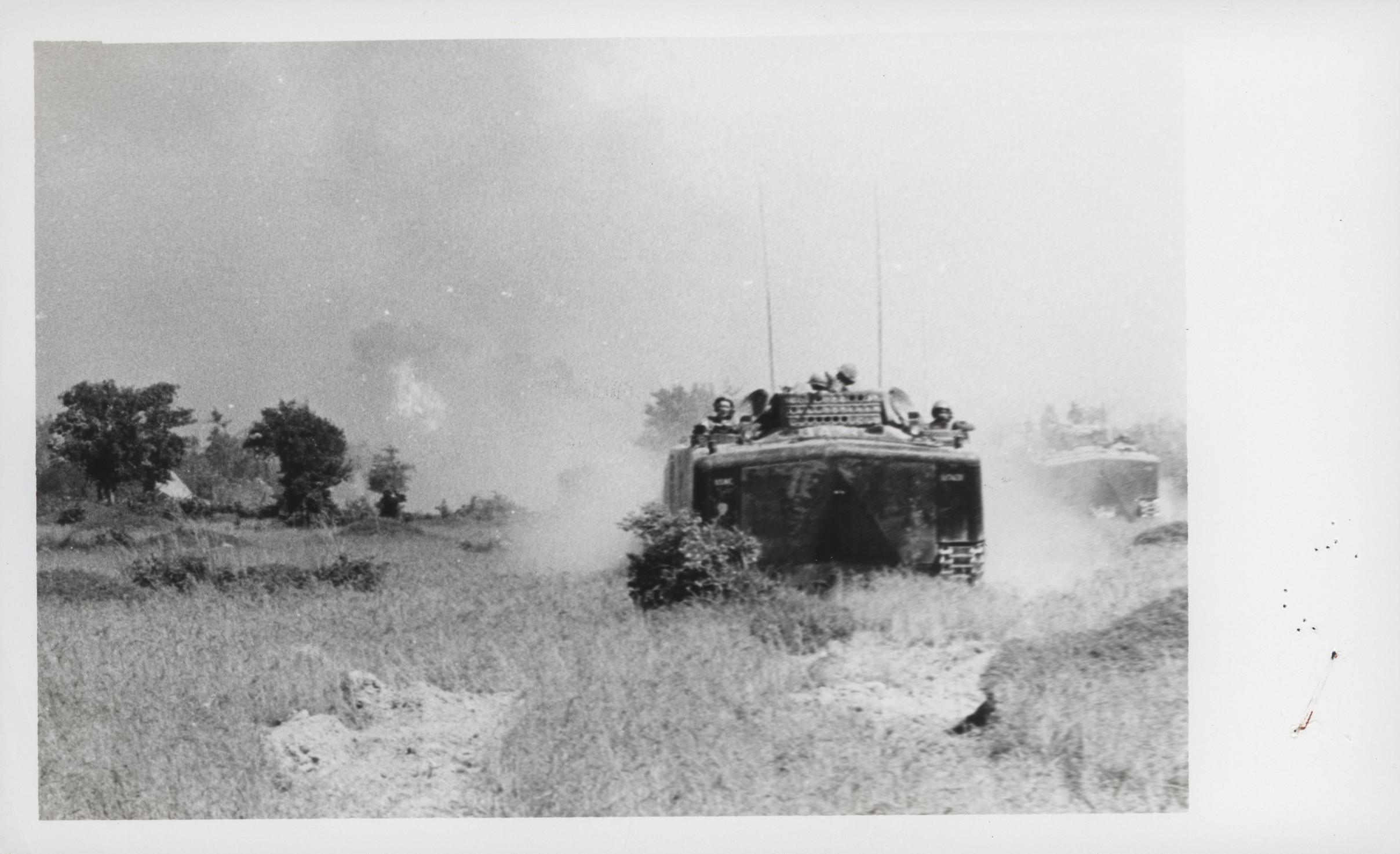 an old picture of a tank driving on it's way through the field