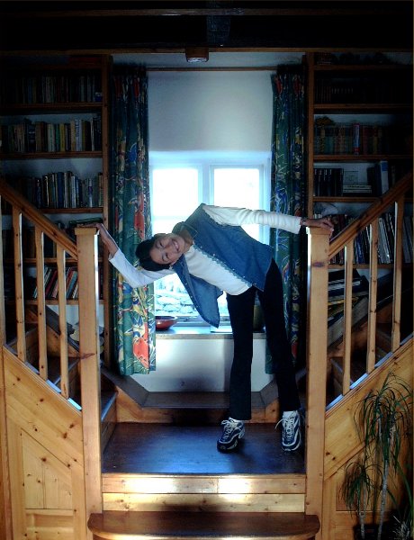 the girl is climbing up the wooden stair railing