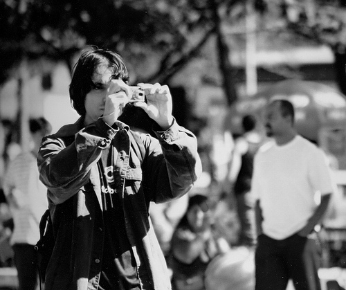 a man looking through his camera at people