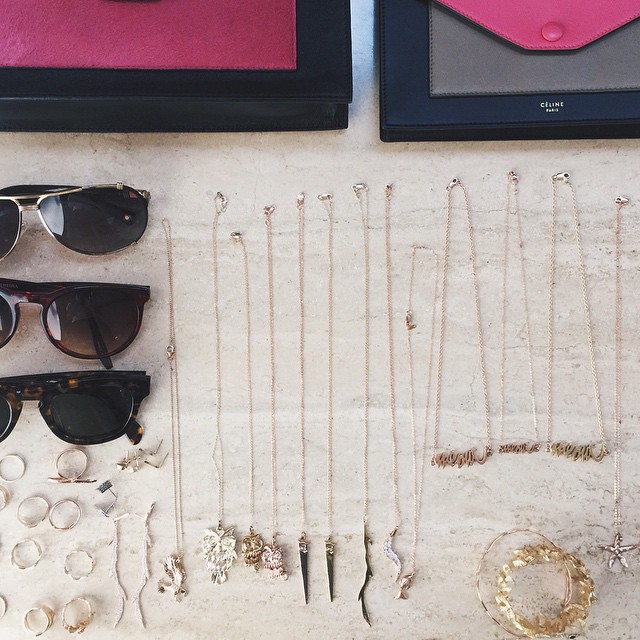 pairs of sunglasses, a case and jewelry on display