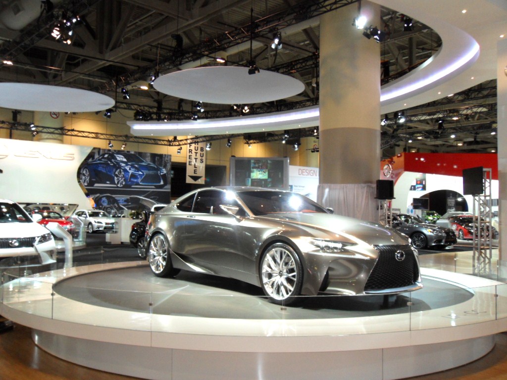 an indoor room shows various cars on display