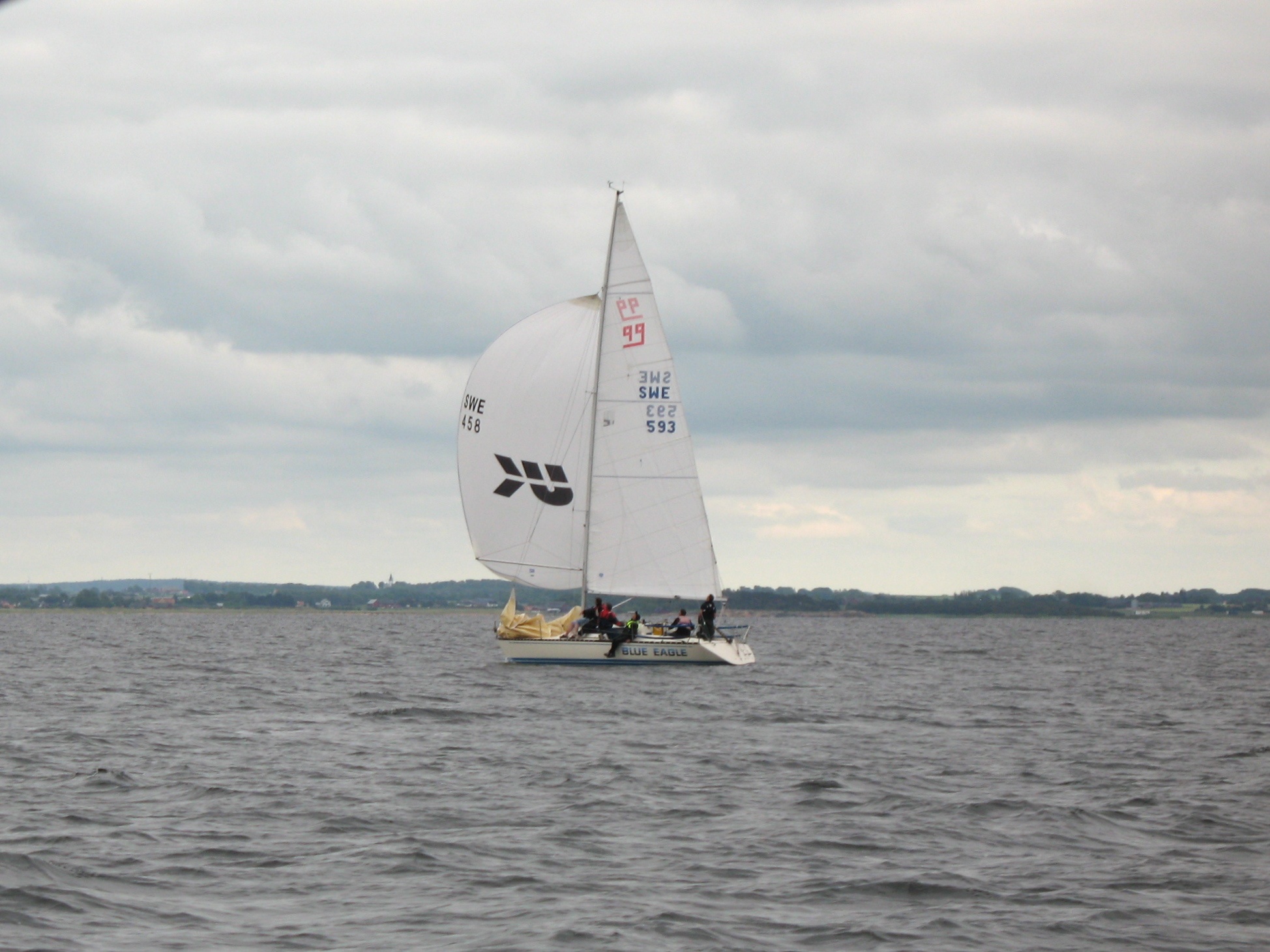 sail boat floating on lake with several people aboard