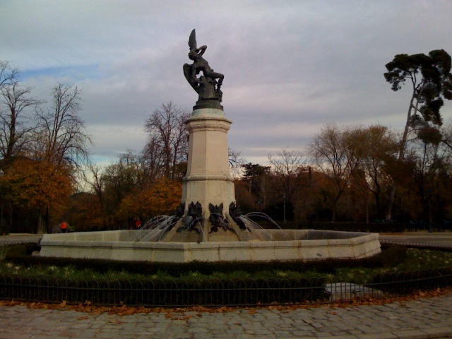 a statue with an angel holding a fish is in the middle of a circular area