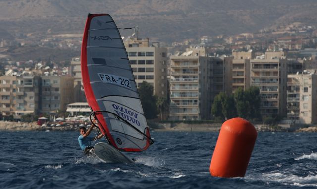 a person windsurfing on the water near some buildings