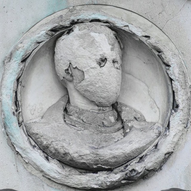 a large round hole in the concrete with an image of a face