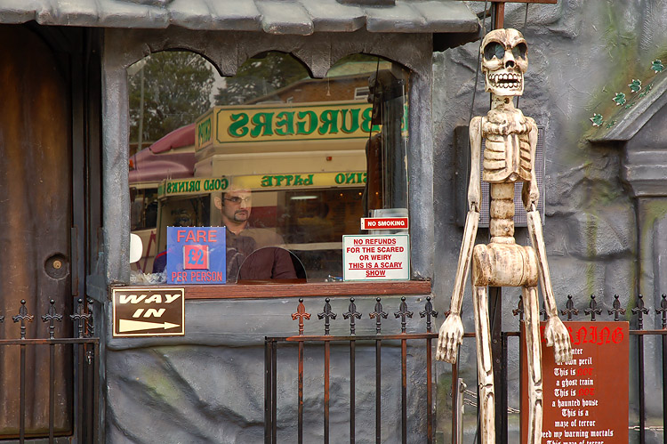 there is a skeleton standing outside a fast food restaurant