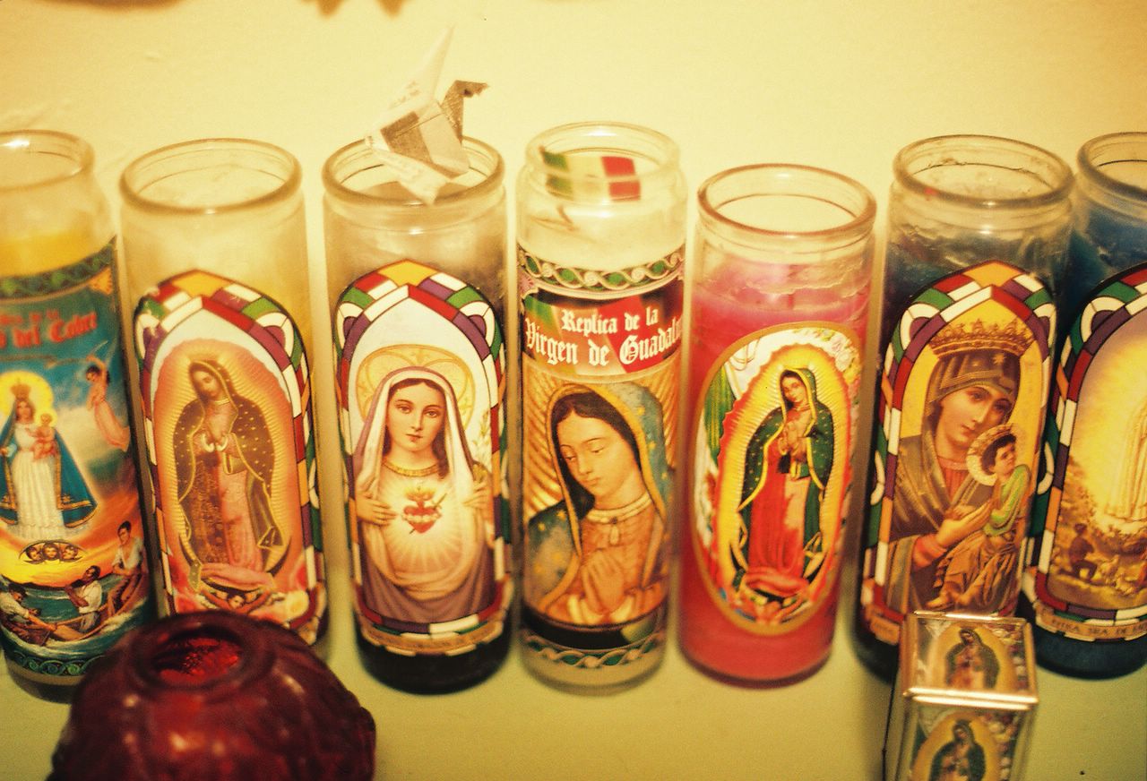 candles with religious scenes in them lined up