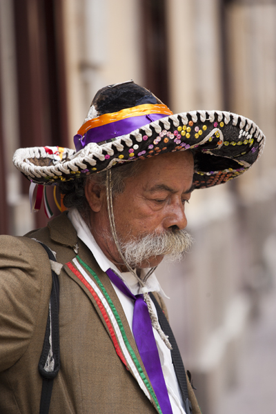 the older man in the sombrero is looking down