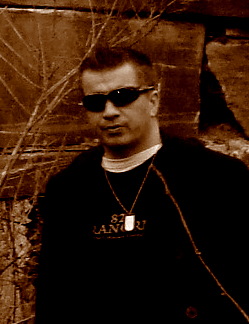a man with sunglasses standing in front of a wall