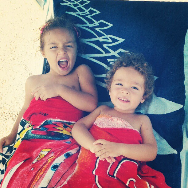 two young s who are laying on a towel