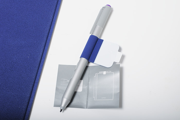 a silver pen sitting next to a blue binder